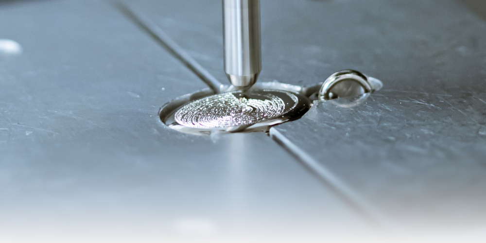 An oval pendant being engraved with a fingerprint.